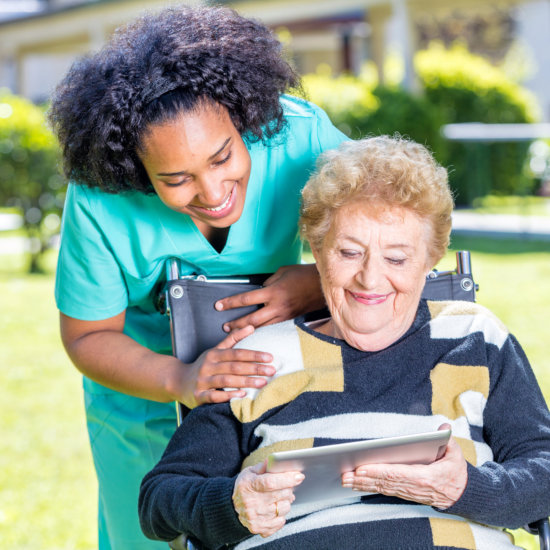caregiver and a senior woman watching video