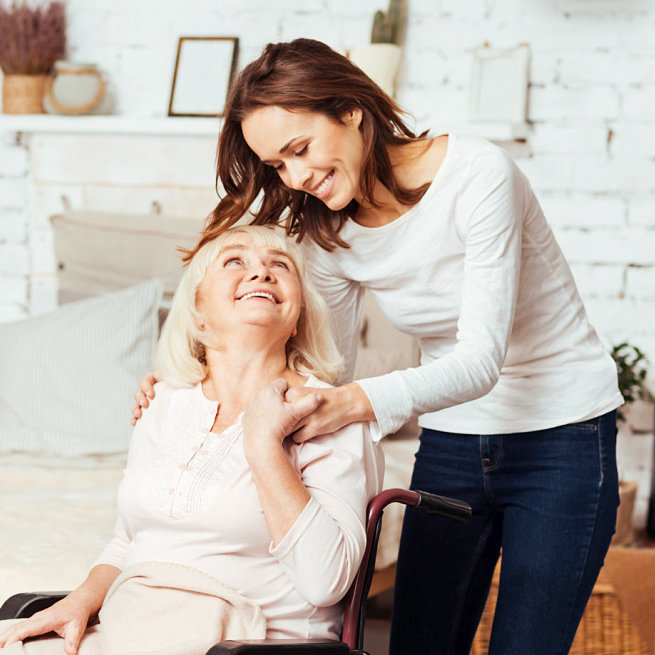 caregiver and a senior woman smiling to each other